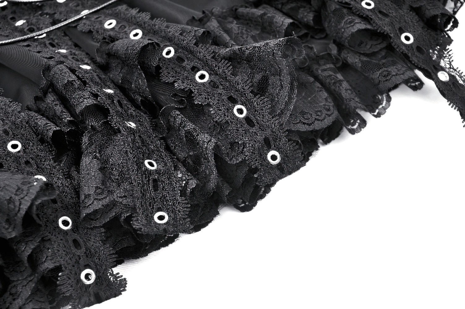 Black lace trim detail on a gothic mini skirt, showcasing edgy eyelet accents and feminine flair.