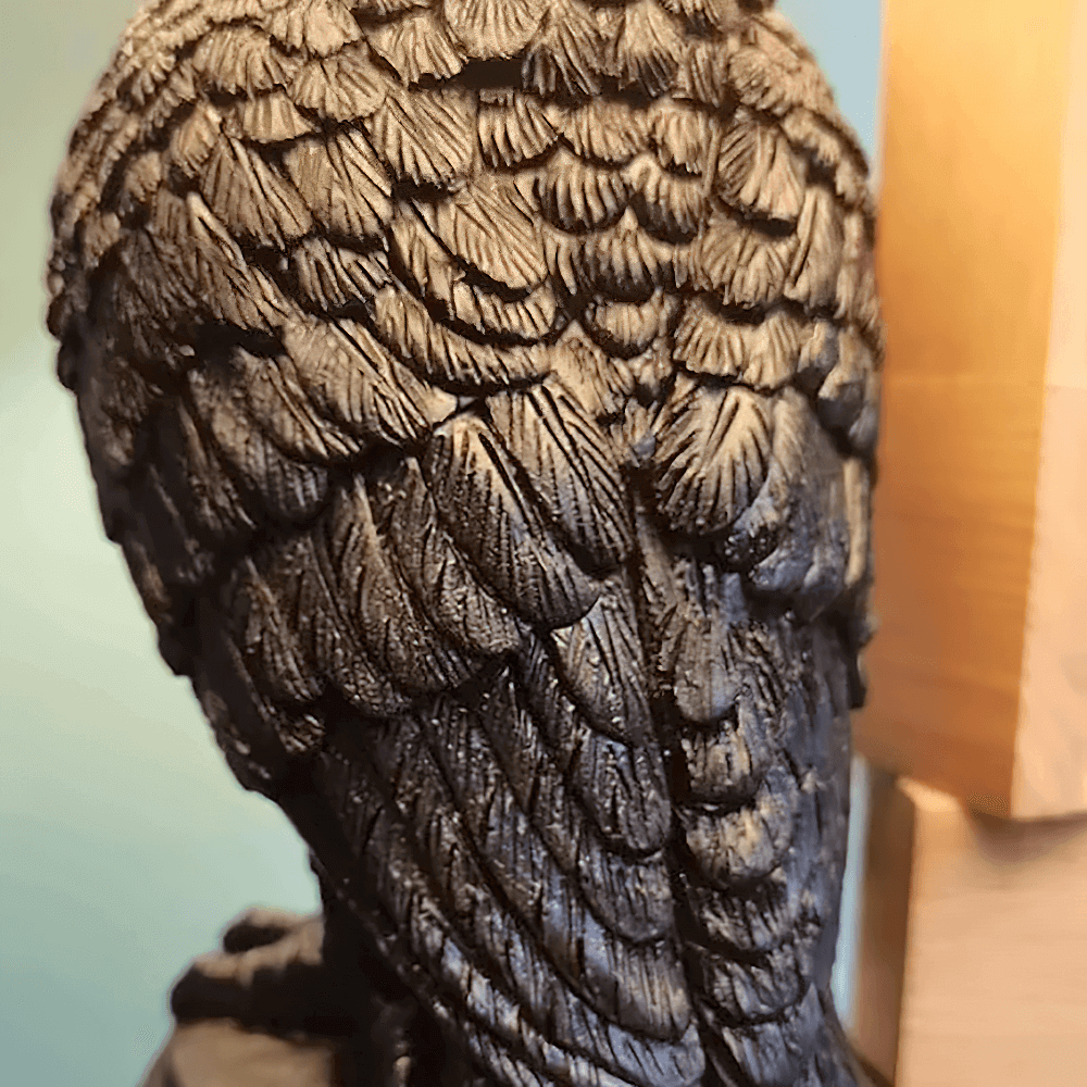 Detailed view of the textured feathers on the back of a dark gothic owl candle holder in black resin.
