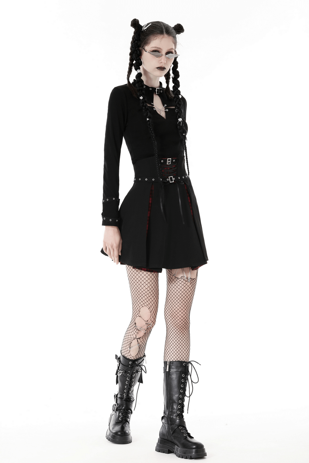 Edgy dark Gothic punk outfit featuring a long-sleeved black cutout crop top, fishnet tights, and chunky lace-up boots.