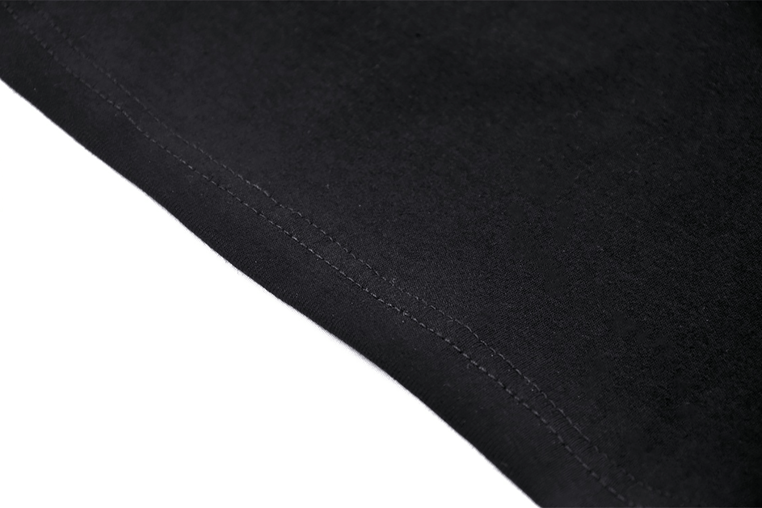 Close-up of the hem of a black crop top, showcasing its sleek stitching and edgy design details.