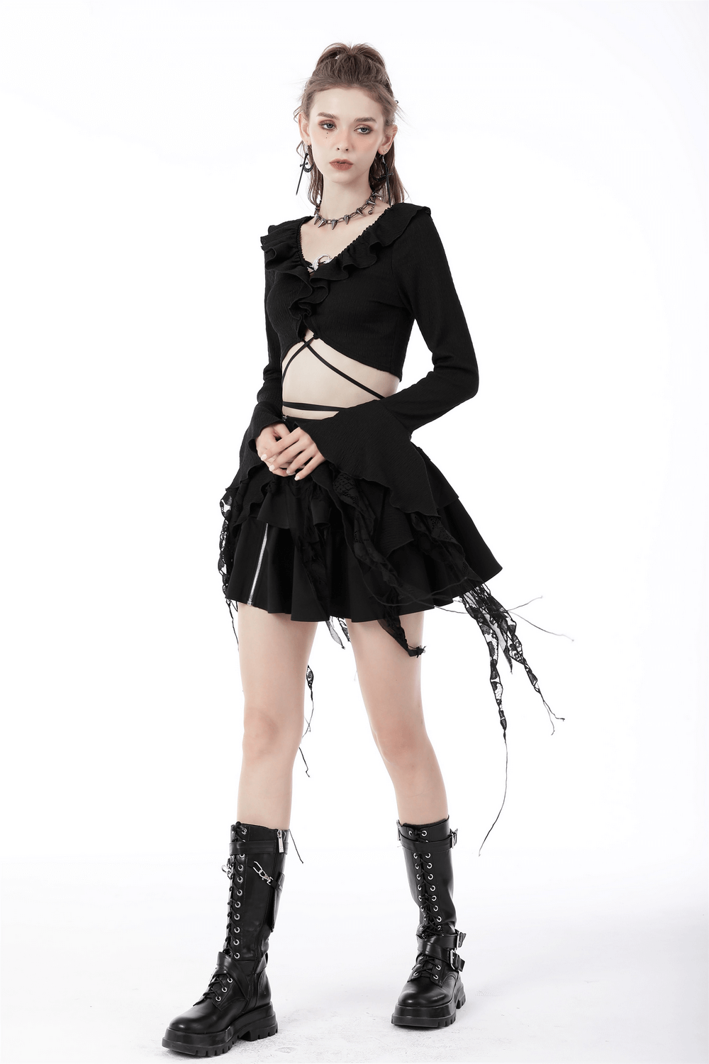 Black gothic crop top with ruffle neck and ripped sleeves, paired with a flouncy skirt and edgy boots.