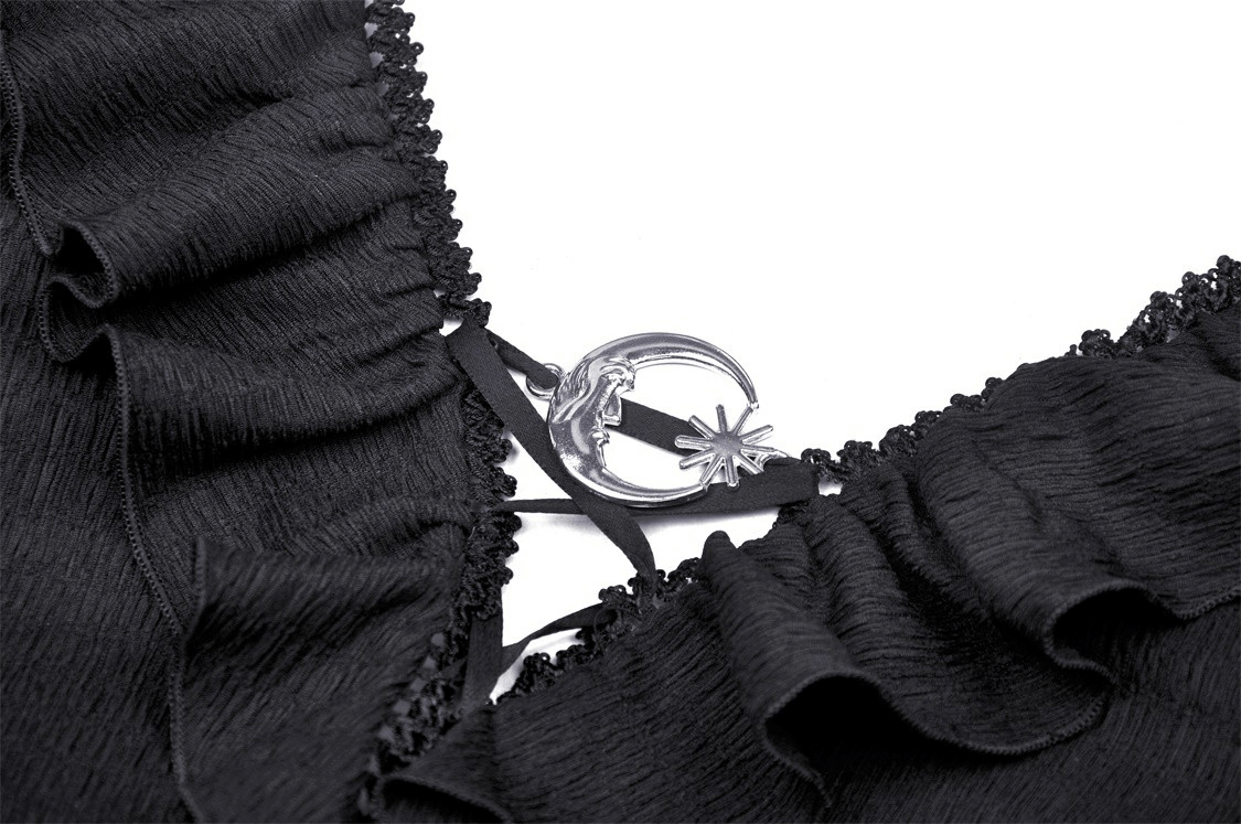 Close-up of dark gothic crop top featuring dramatic ruffle neck and celestial charm detail.