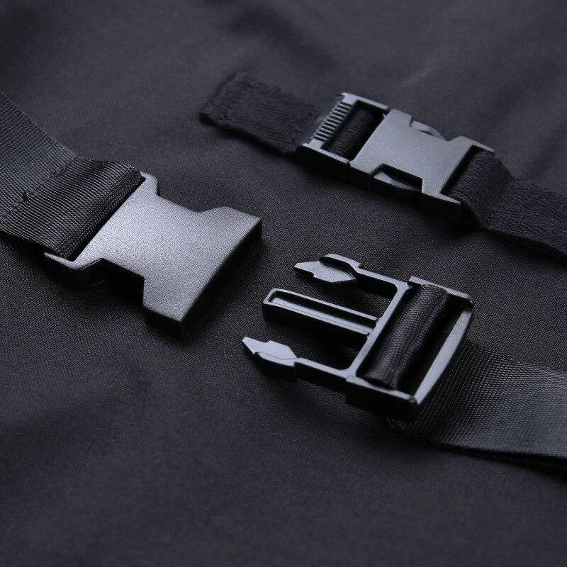 Close-up of detachable shoulder belt buckle on dark gothic style long sleeve dress in black fabric.