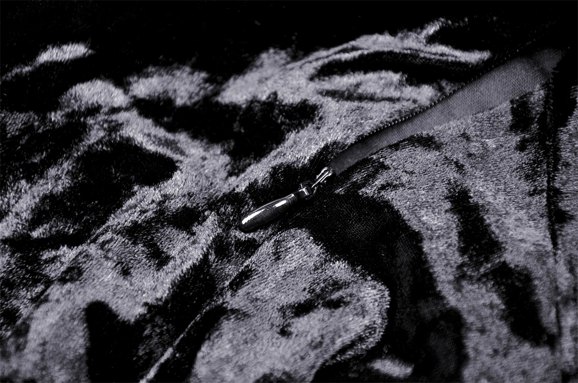 Close-up of luxurious black velvet fabric with a zipper, perfect for a gothic mini dress design.