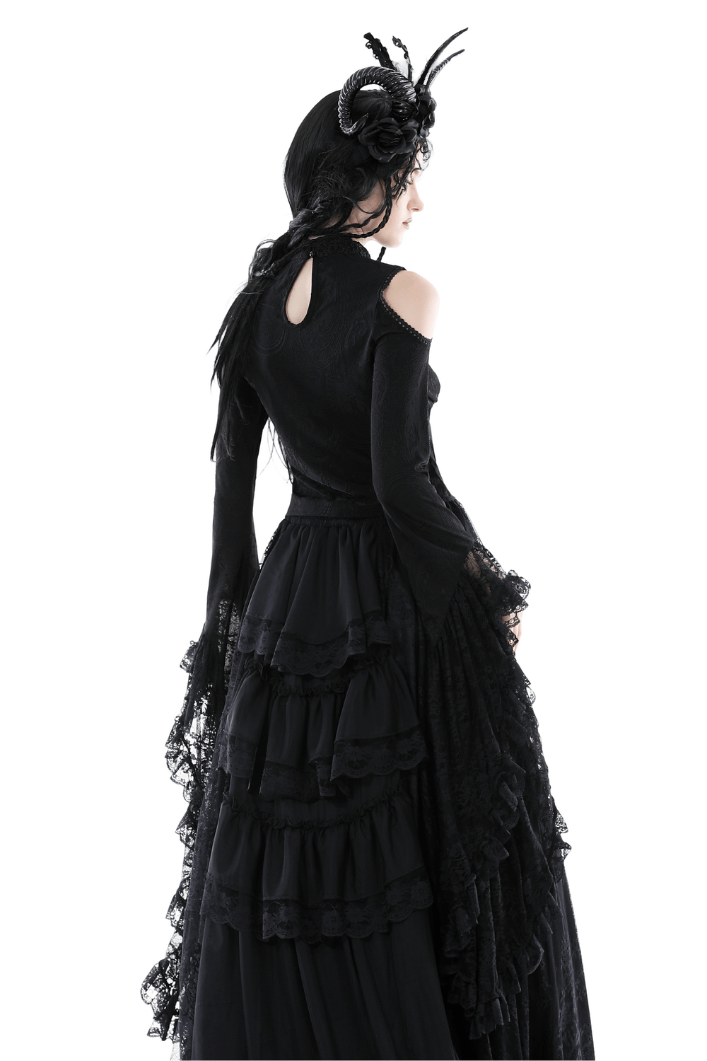 Back view of a gothic woman in a black lace off-shoulder top and layered skirt, exuding Victorian elegance.