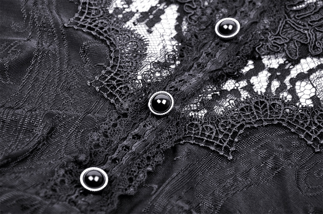 Close-up of dark lace fabric with black buttons, showcasing intricate damask and mesh details.