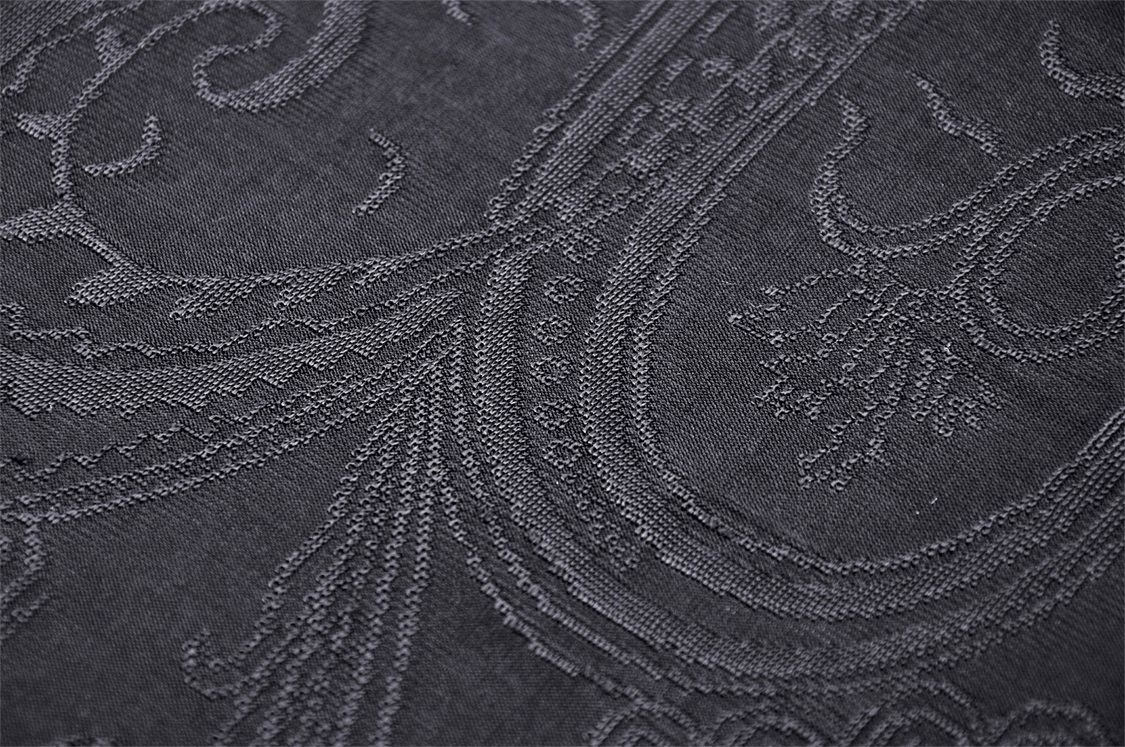 Close-up of intricate black damask fabric showcasing Gothic Victorian design patterns.