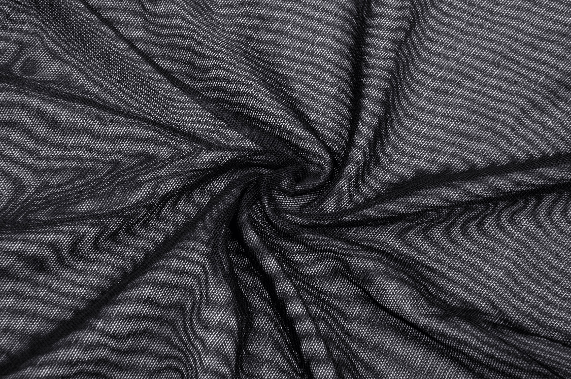 Close-up of sheer black mesh fabric with a wavy texture, perfect for edgy fashion layering or gothic clothing.