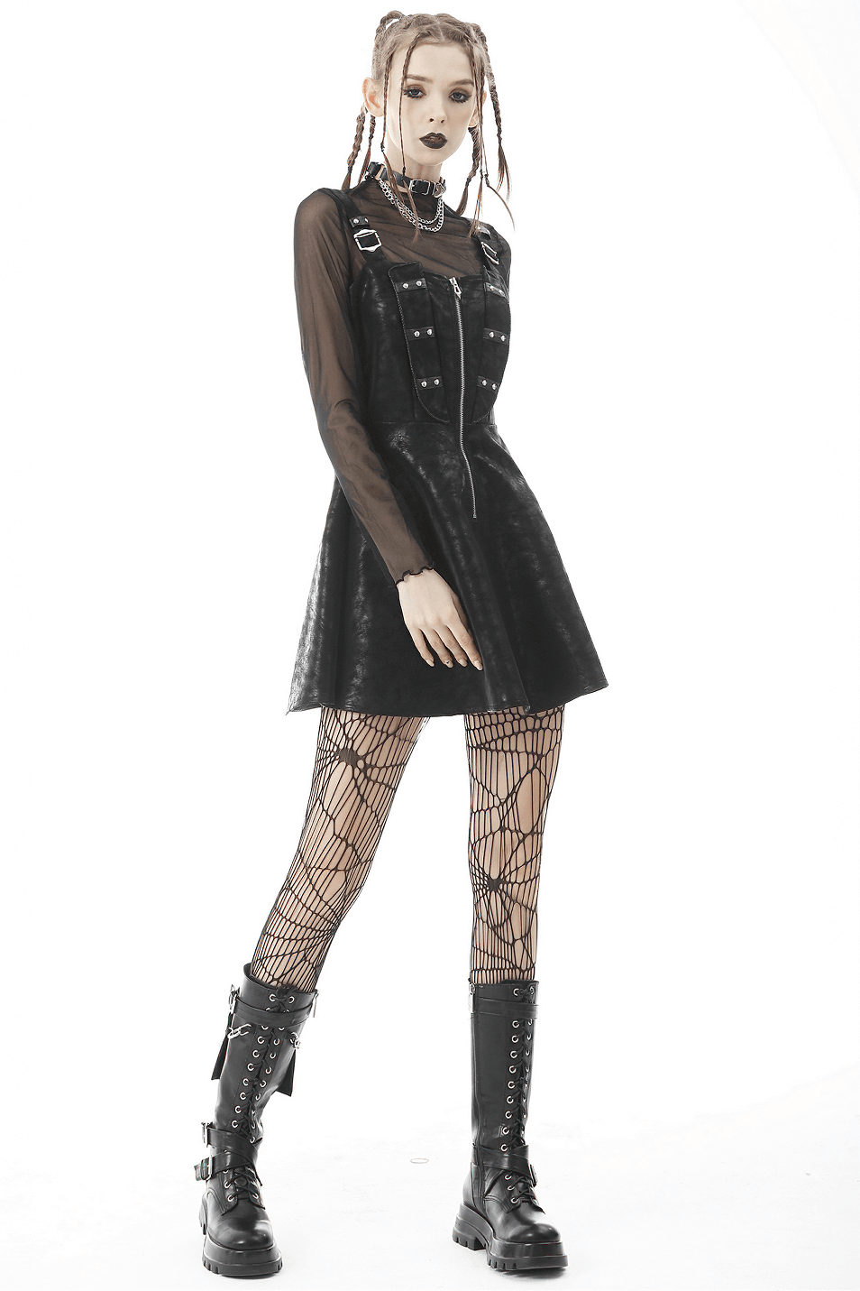 Gothic model in a black leather dress with fishnet tights and combat boots, showcasing edgy rave fashion.