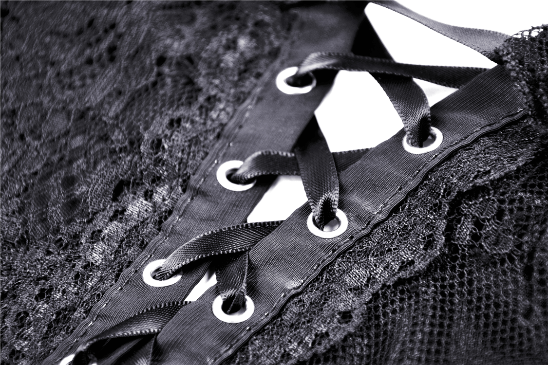Close-up of dark lace with ribbon lacing detail, perfect for goth fashion and edgy dress designs.