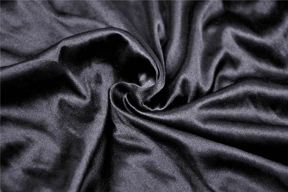 Close-up of luxurious dark satin fabric showcasing a silky smooth texture.