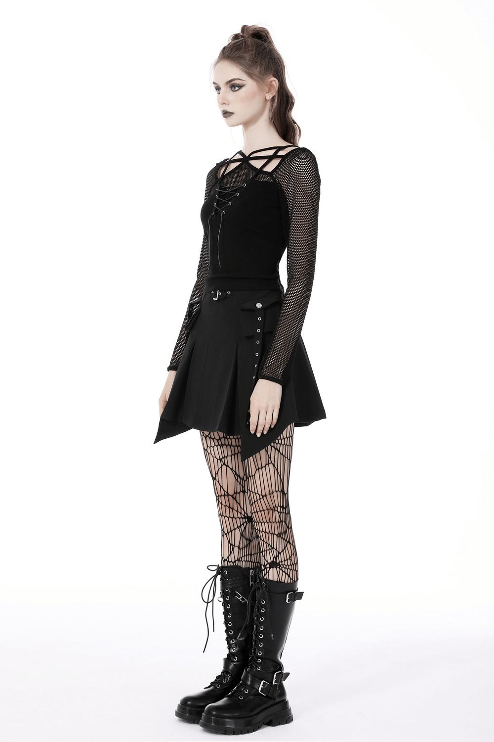 Stylish model in dark punk gothic lace-up top with mesh sleeves, black skirt, and fishnet tights, perfect for edgy fashion.