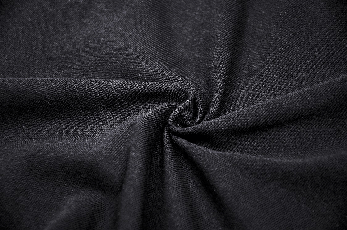 Close-up of soft black stretchy fabric, ideal for dark punk gothic apparel, showcasing its texture and quality.