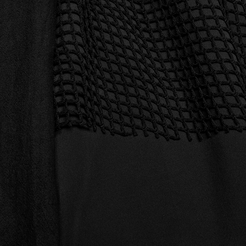 Close-up of dark punk harem pants featuring textured mesh layers and soft fabric for a bold streetwear style.