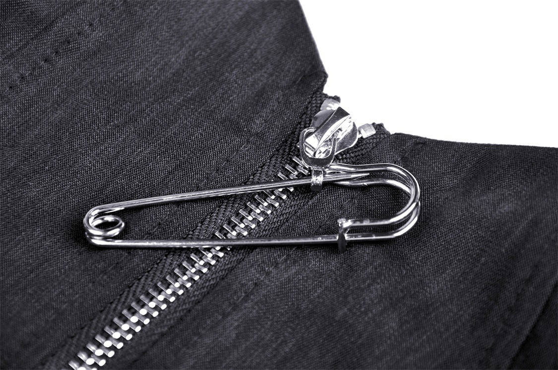 Close-up of a metal zipper and safety pin on a dark punk crop top, perfect for a gothic fashion statement.