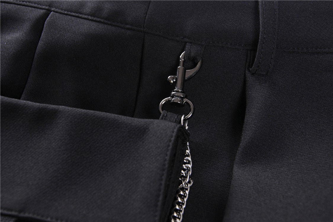 Close-up of the edgy chain detail on the black pleated mini skirt with pocket.