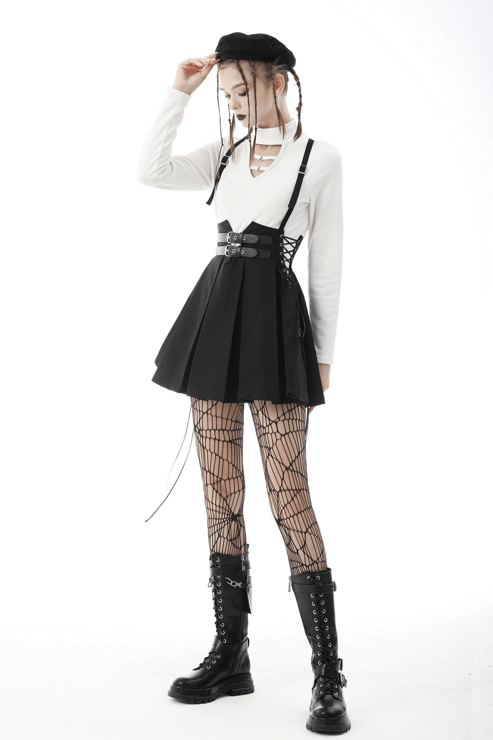 Gothic dark punk suspender skirt with buckle detailing, styled with fishnet tights and combat boots.