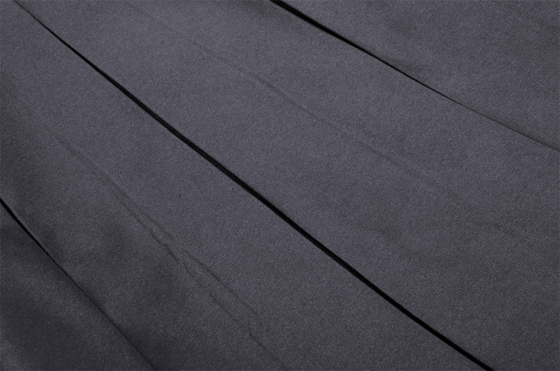 Close-up of dark pleated fabric showcasing the texture of the Gothic suspender skirt.