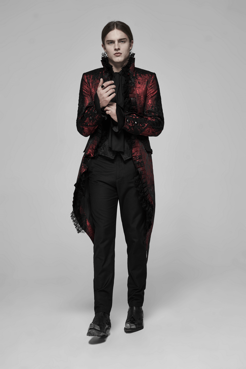 Gothic model showcasing dark red Rococo lace tuxedo coat with ruffles and stylish black pants.