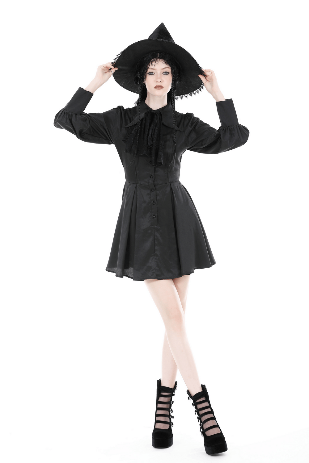 Model in a black ruffled neckline long-sleeved dress with a witch hat, exuding dark romance style.