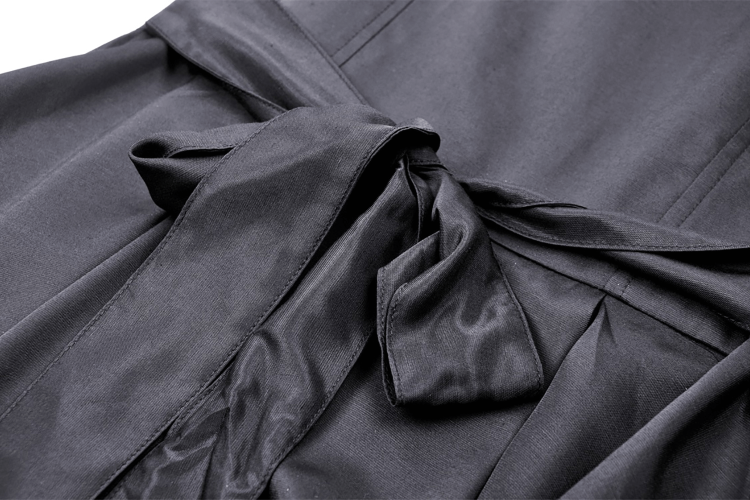 Close-up of the elegant bow detail on the ruffled neckline of a black Victorian-style dress.