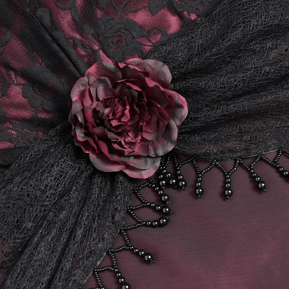 Close-up of black lace with wine red flower and beaded fringe, capturing gothic elegance and romance.