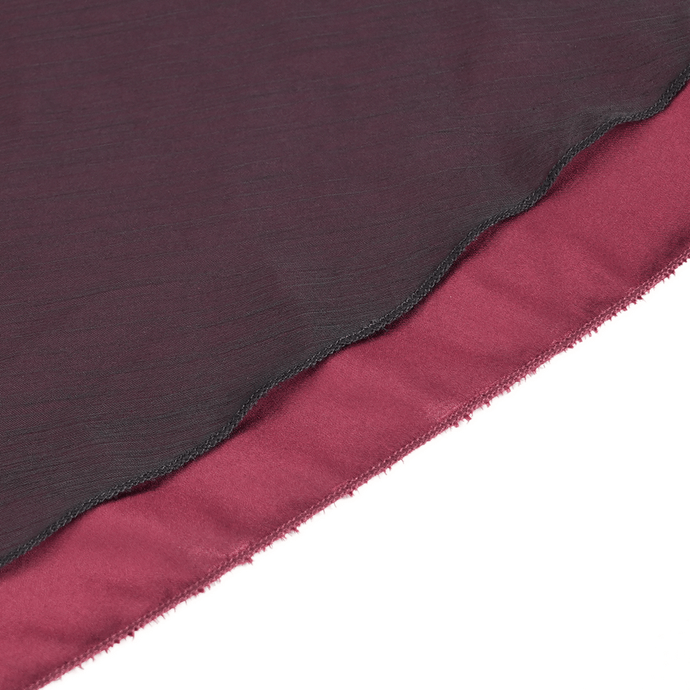 Close-up of dark wine red and black fabric layers showcasing luxurious textures for gothic fashion.