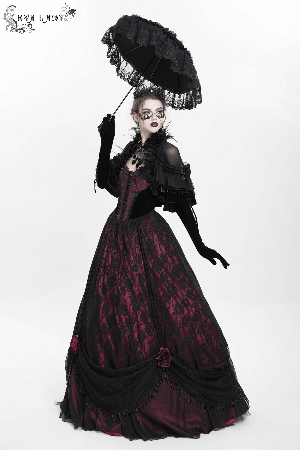 Dark romantic gothic gown in black lace with wine red accents, complemented by a parasol for a stylish evening look.