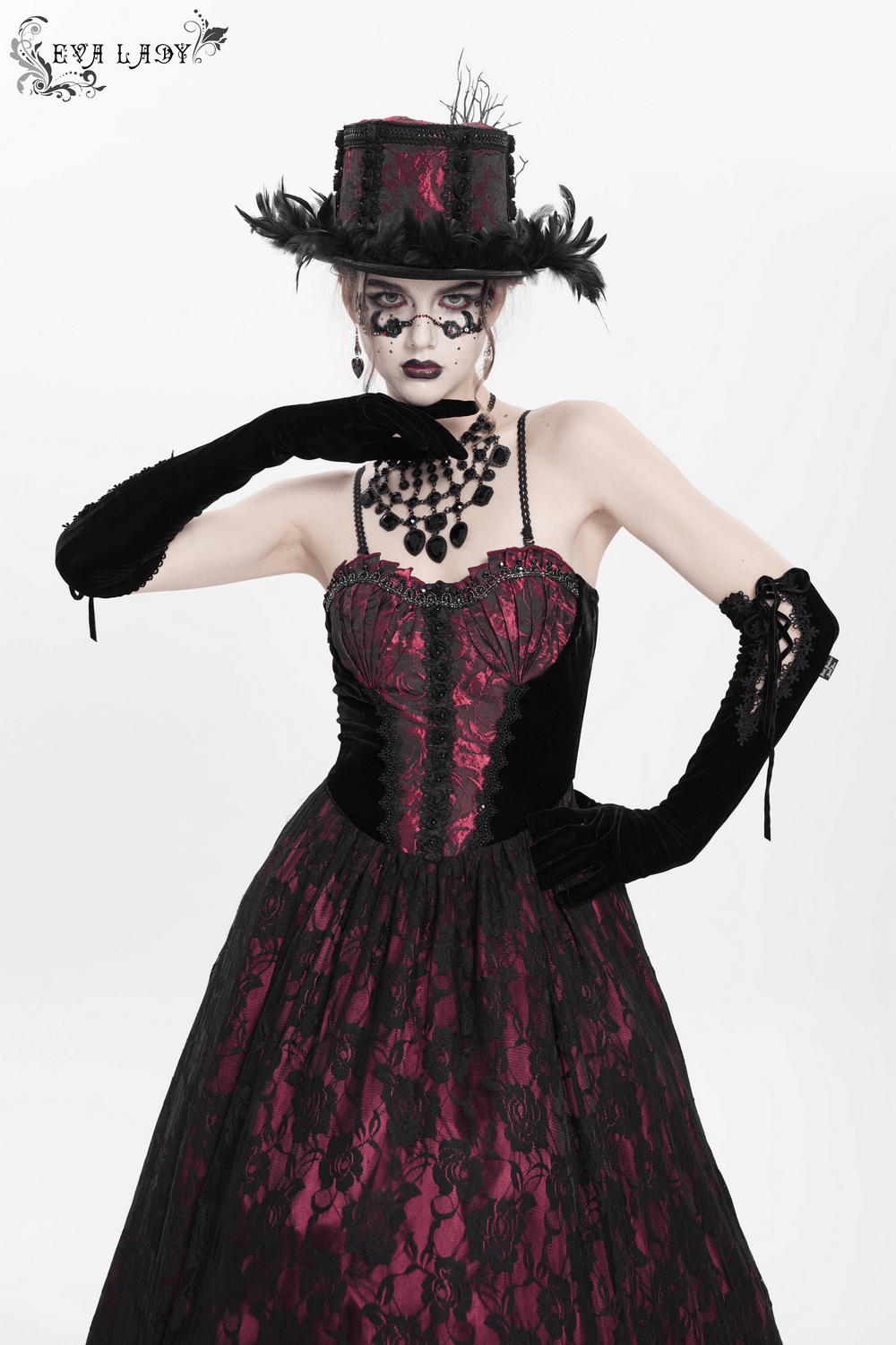Dark romantic gothic gown with floral lace, wine red corset, and dramatic accessories, showcasing elegant vintage style.
