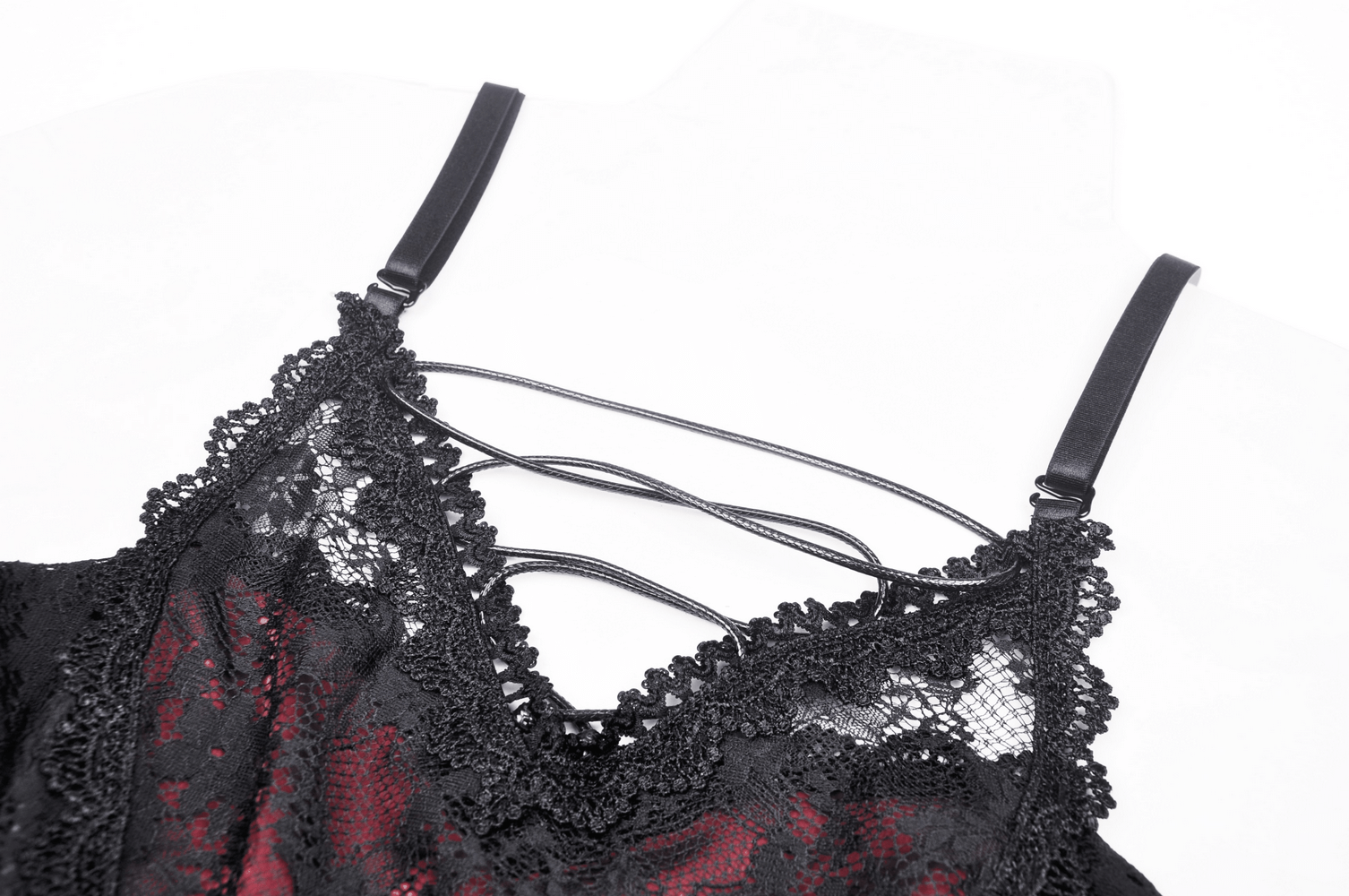 Close-up of black lace with crisscross straps on a gothic off-shoulder mini dress, showcasing intricate details.