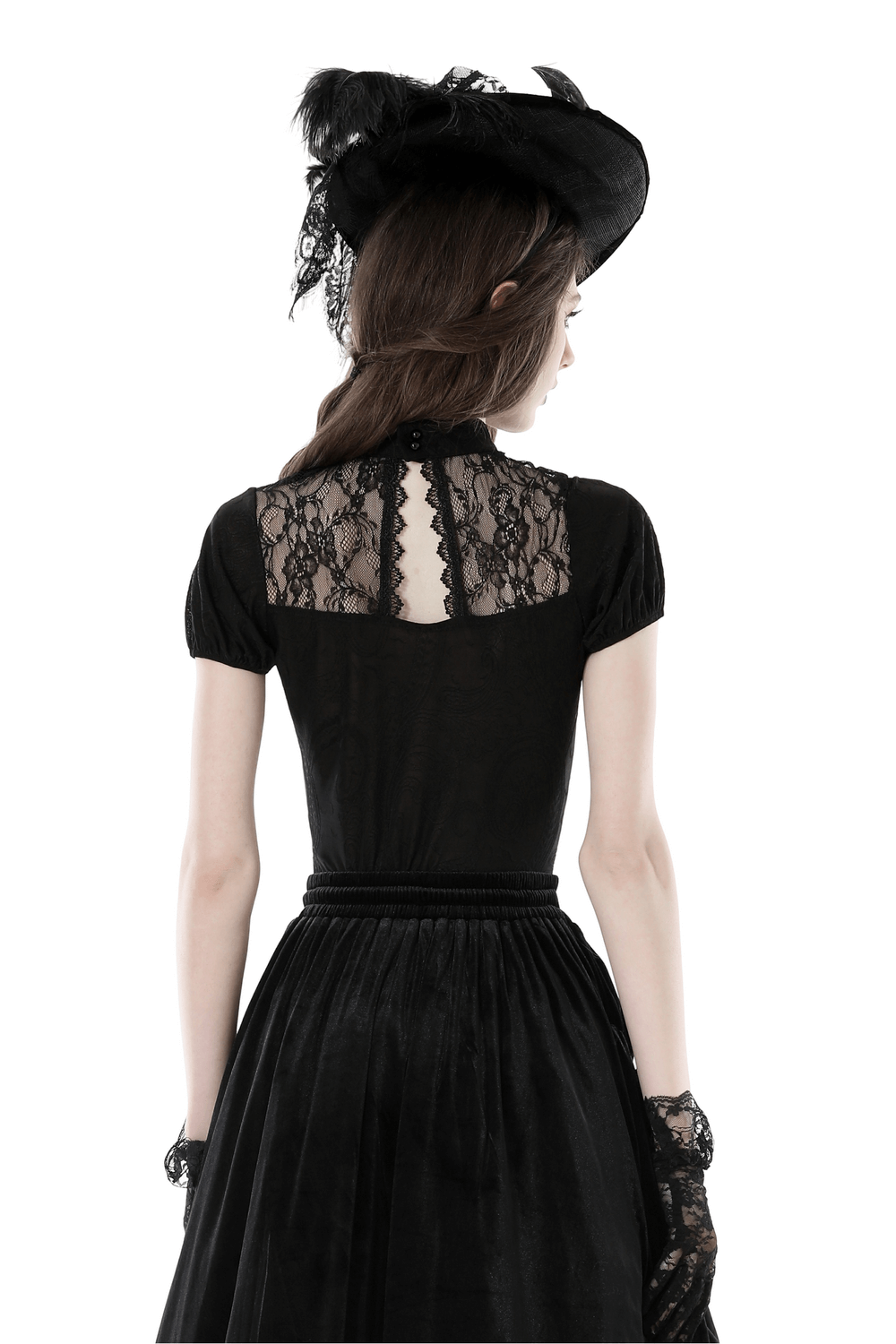 Back view of a woman in a black gothic lace top with short puff sleeves and a stylish fascinator hat.