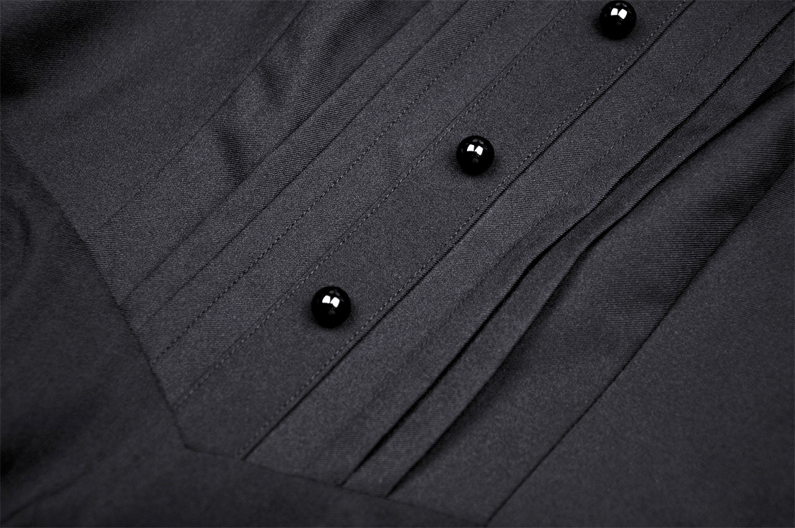 Close-up of a dark fabric featuring stylish black buttons and pleated details, perfect for a gothic dress.