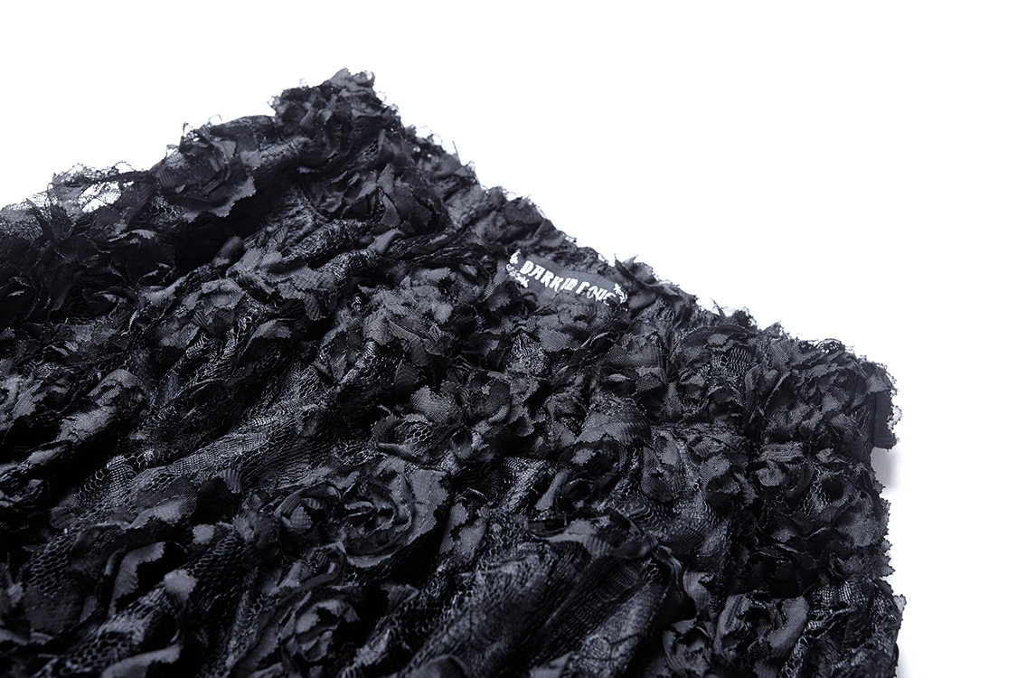 Close-up of a black layered mesh maxi skirt with floral textures and a fitted waistband.