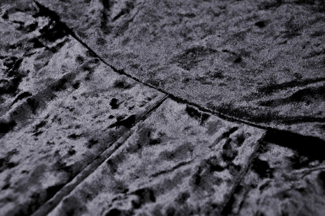 Close-up of luxurious black velveteen fabric, showcasing rich texture and softness, perfect for gothic fashion.