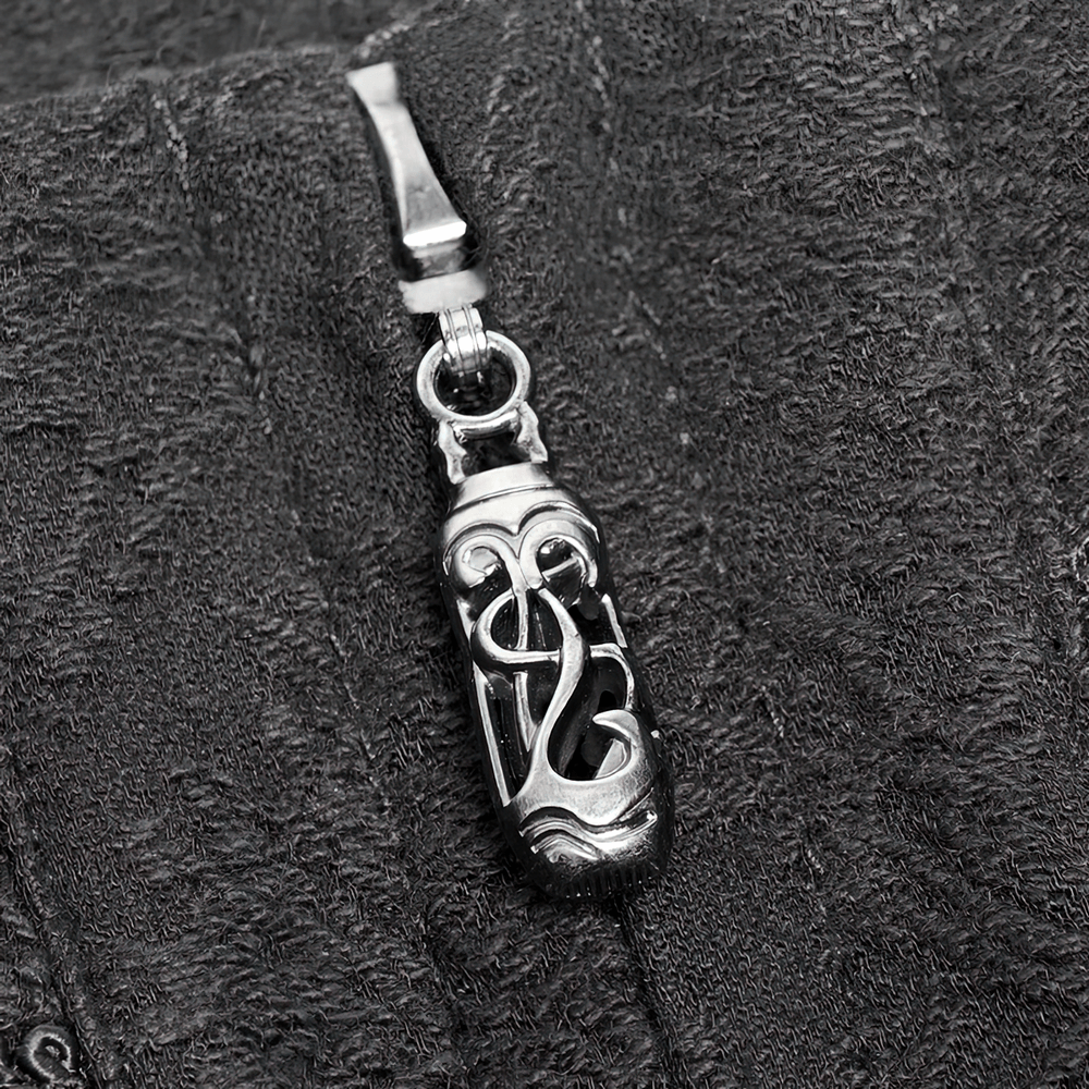 Close-up of intricate silver zipper pull on dark textured fabric, perfect accent for gothic fashion.