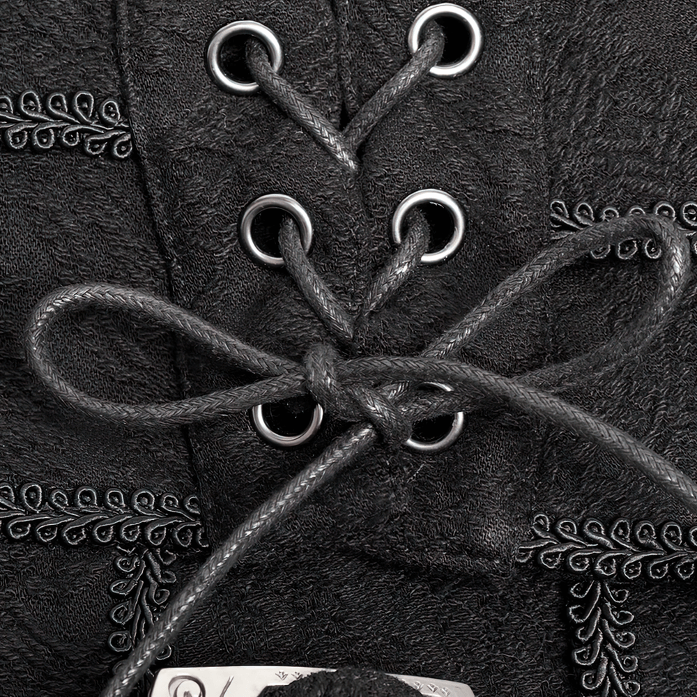 Close-up of vintage black lace-up detail on a dark Victorian skirt with embroidered accents.