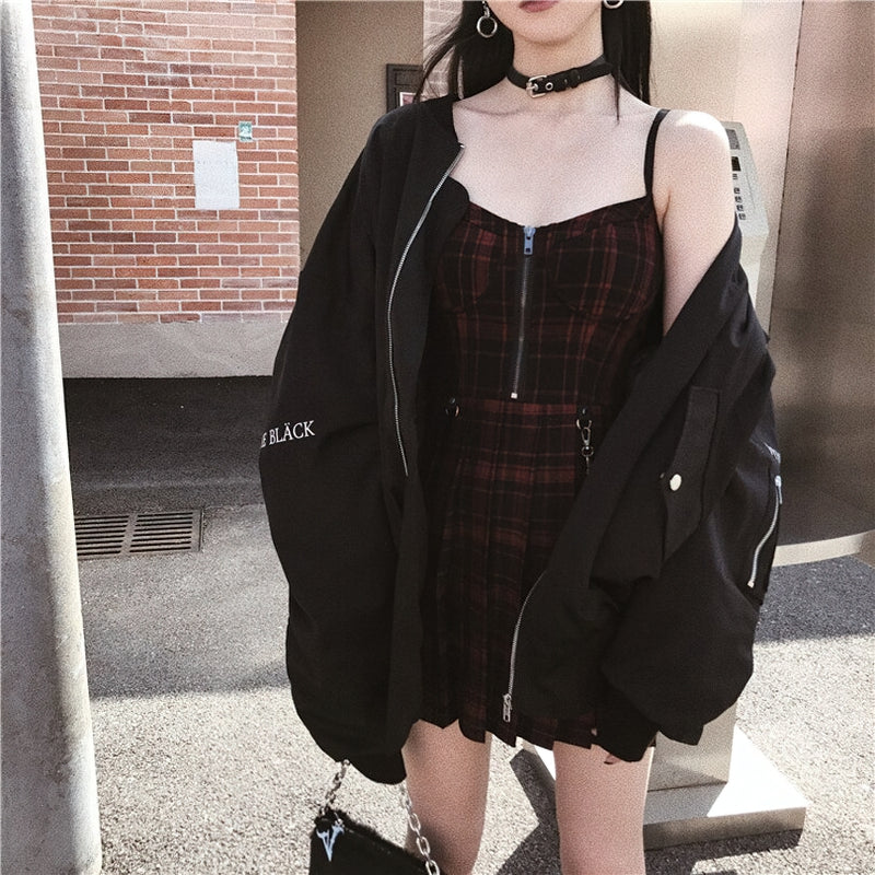 Stylish woman in a dark plaid Gothic mini dress with zipper and oversized jacket for a trendy street look.