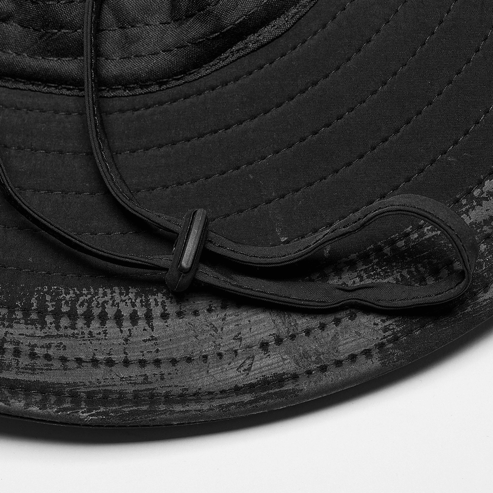 Close-up of the distressed woven hat's adjustable brim and chin strap, showcasing its rugged, breathable design.