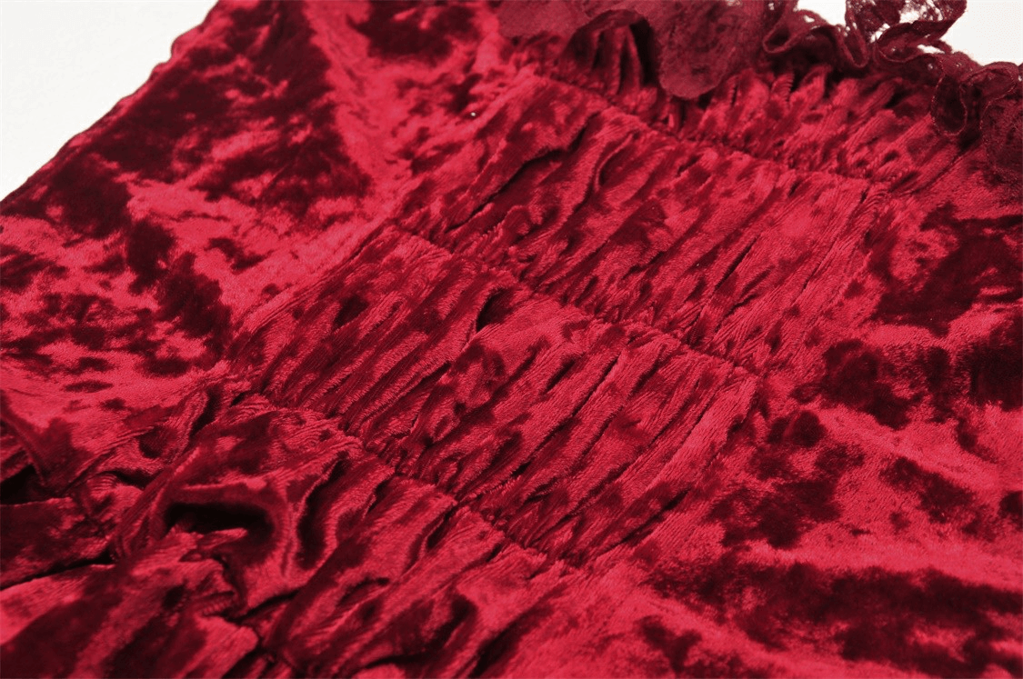 Close-up of deep red velvet fabric showing dramatic cross bodice detail and elegant texture for gothic maxi dress.