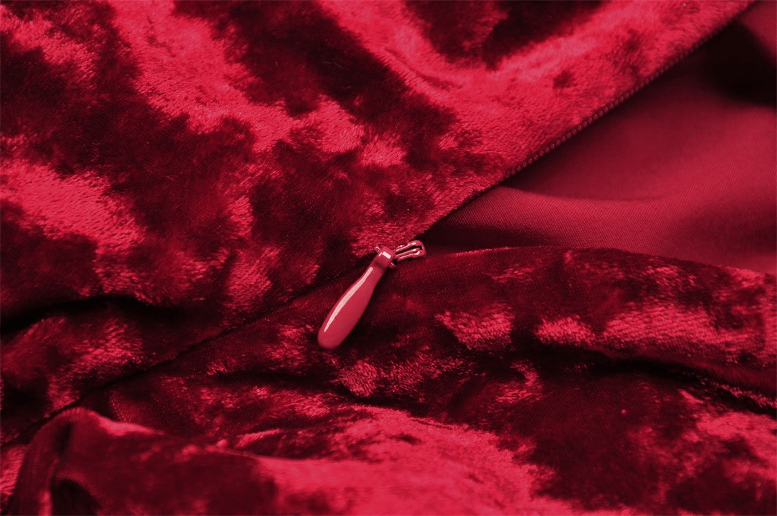Close-up of deep red velvet fabric with zipper detail, showcasing luxurious texture for gothic elegance fashion.