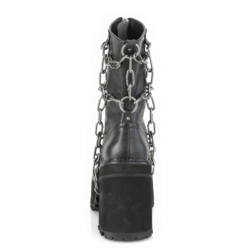 Demonia black ankle boots with bold block heel and striking metal chain detailing from the back view.