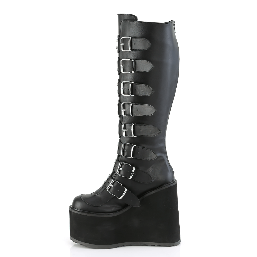 Demonia black buckled knee-high platform boots with vegan leather and metal plates, featuring wide calf design.