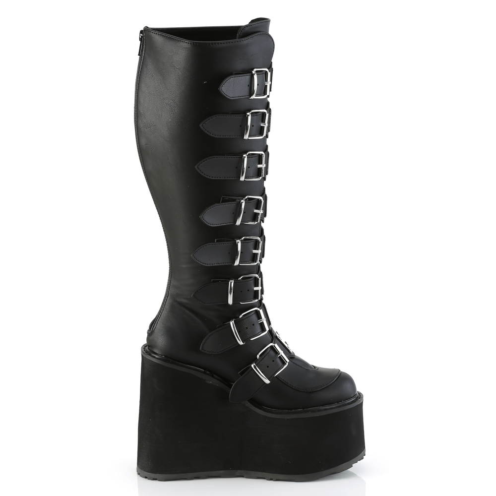 Demonia black buckled knee-high platform boots featuring a 5.5-inch platform and eight buckle straps, crafted in vegan leather.