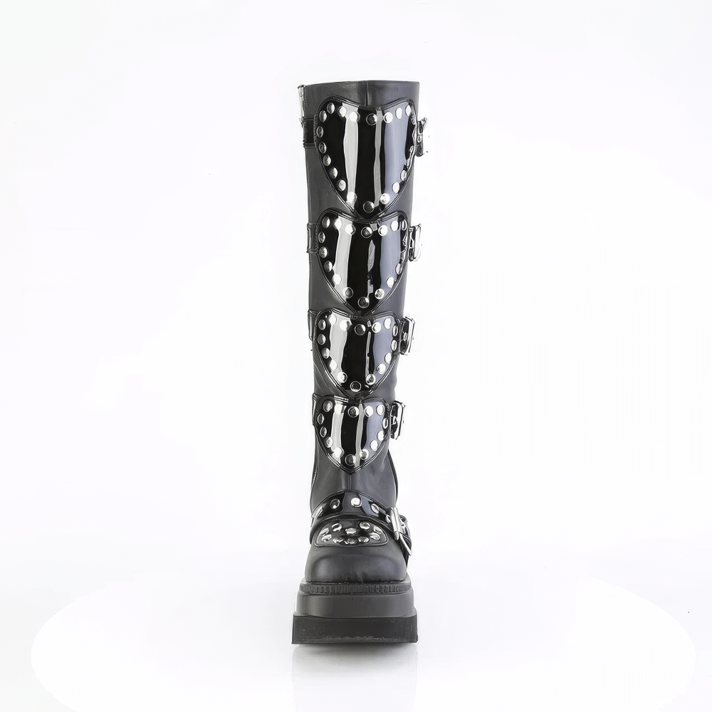 Demonia black knee-high platform boots featuring heart shields and studs, showcasing a bold gothic style.