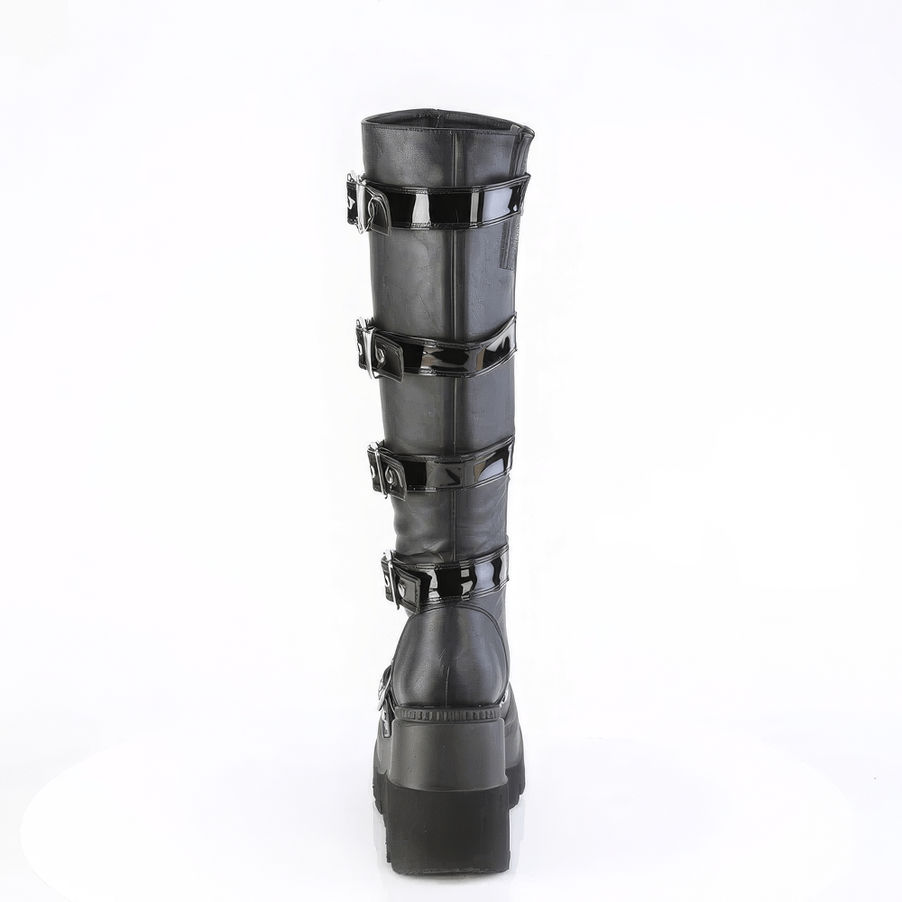 Demonia black knee-high platform boots with heart shields and studs, featuring a sleek buckled design.
