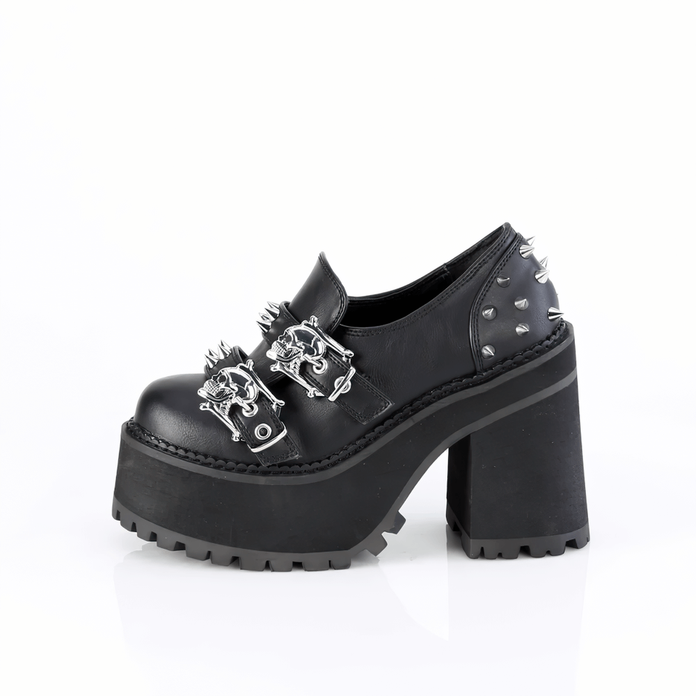 Demonia black platform loafers with double skull buckles and cone spikes, featuring a 4 3/4" block heel.