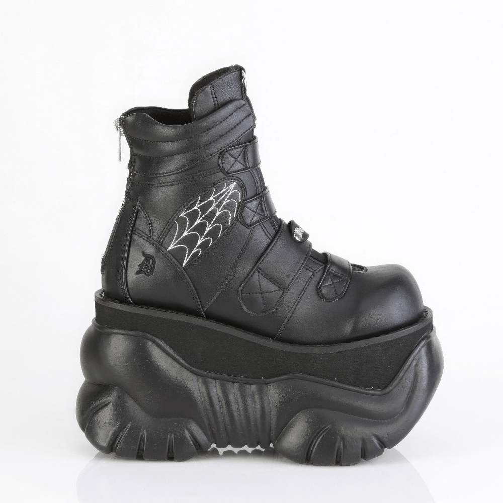 Black Demonia platform boots with spider web design, padded collar, and metal zip for a gothic look.