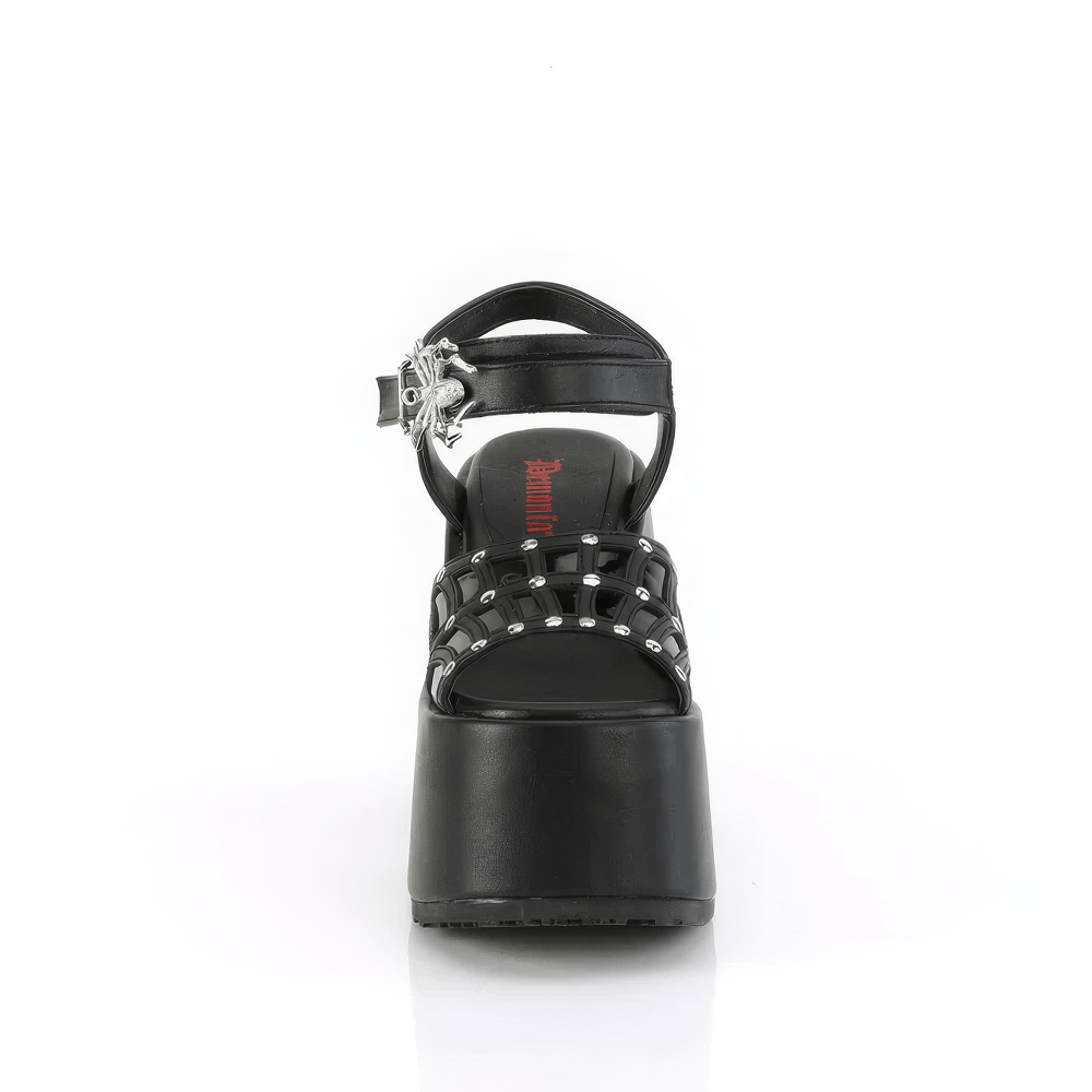 Front view of DEMONIA chunky heel ankle strap sandals with spider buckle and silver studs in black vegan leather.