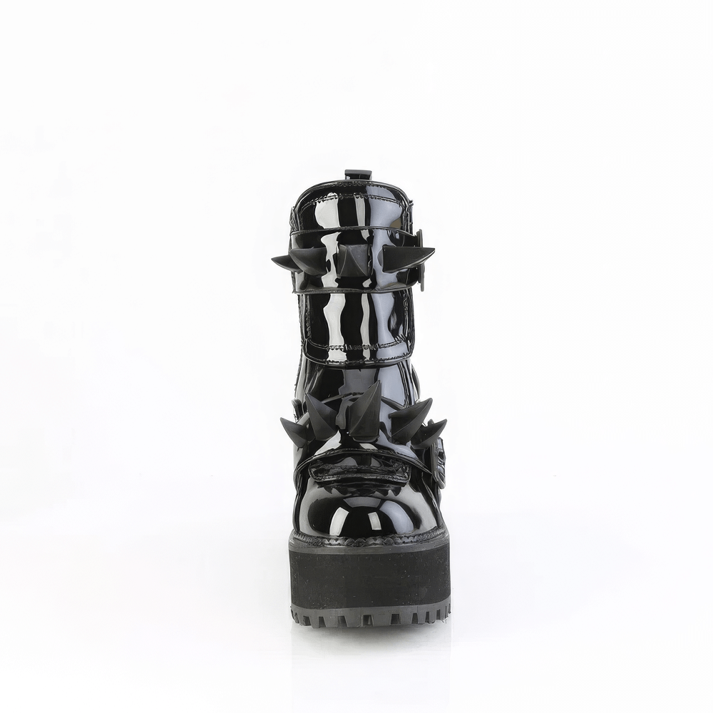 Front view of DEMONIA glossy black ankle boots with coffin buckle and spike details.