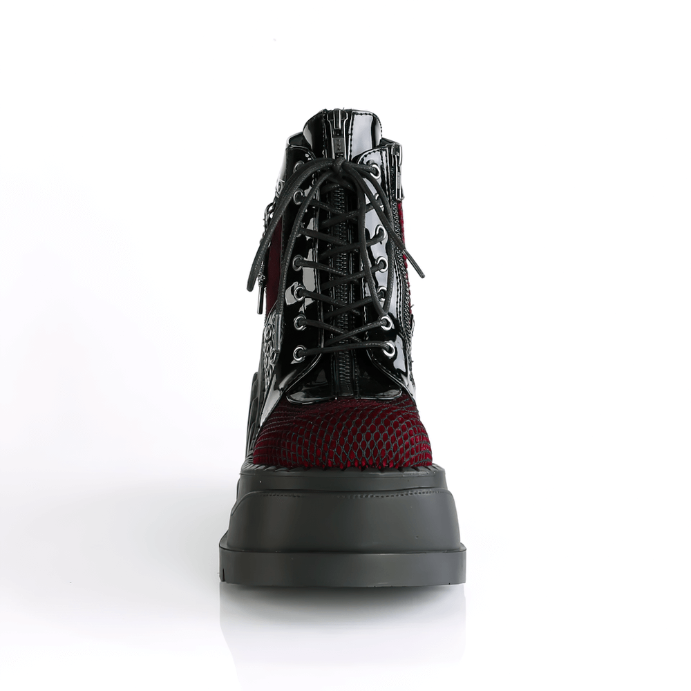 Front view of Demonia Gothic platform booties in burgundy and black with fishnet and charms.